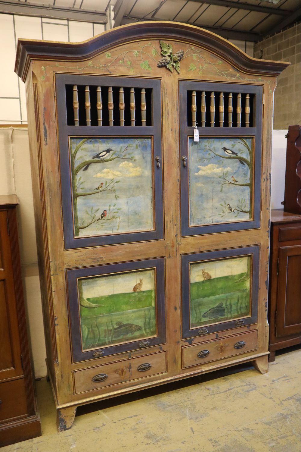 A 19th century Continental painted armoire, later decorated with birds on branches, rabbits and fish, the top two doors each enclosing